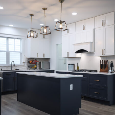 Modern kitchen renovation in Bristow with black cabinets, white countertops, spacious layout, and sleek, functional design.