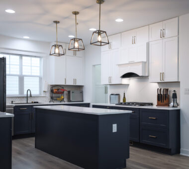 Modern kitchen renovation in Bristow with black cabinets, white countertops, spacious layout, and sleek, functional design.